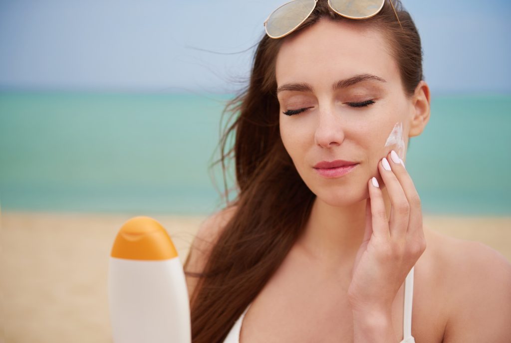young-beautiful-woman-applying-sun-cream-beach