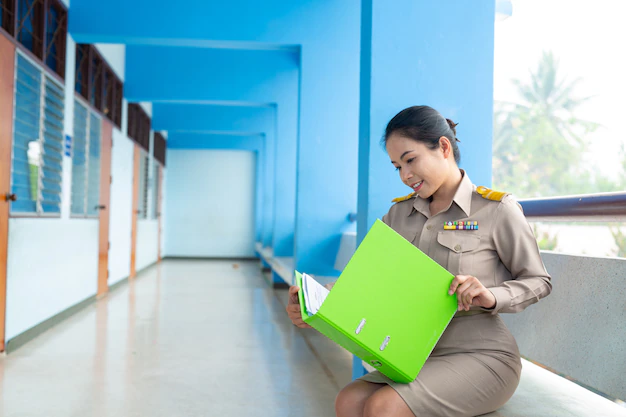 thai-teacher-official-outfit-is-checking-file-folder 1150-20611