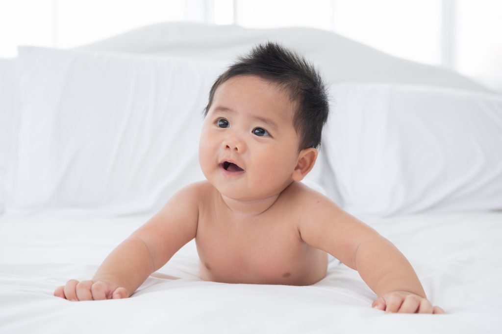 baby-boy-wearing-diaper-white-sunny-bedroom