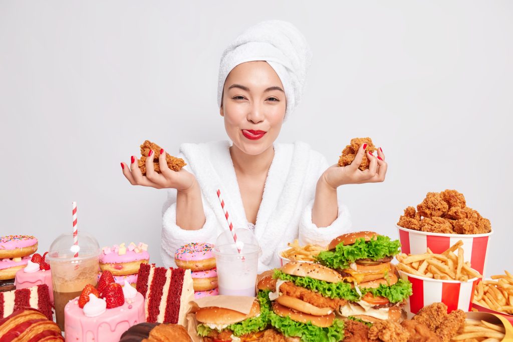 satisfied-young-asian-woman-with-red-lipstick-manicure-holds-delicious-nuggets-addicted-fast-food