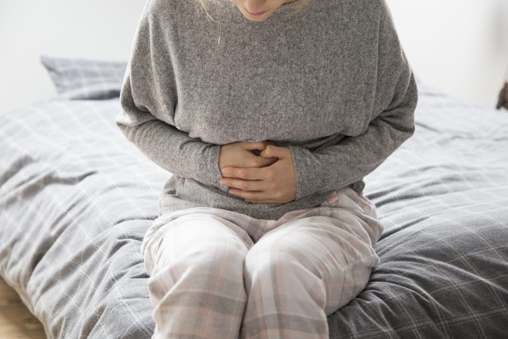 sick-woman-with-hands-stomach-suffering-from-intense-pain